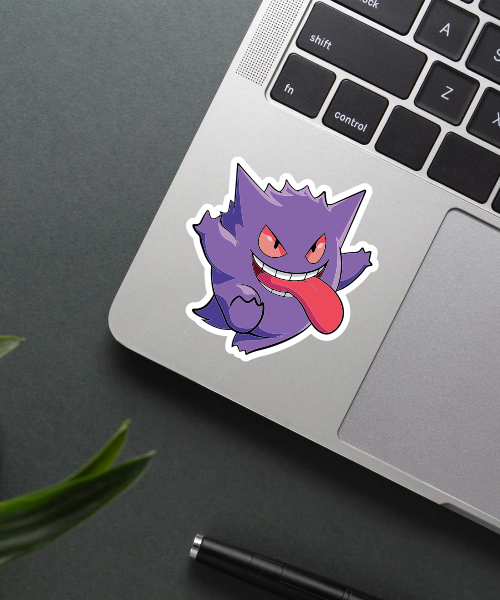 gengar pokemon cartoon sticker on laptop surface showing playful purple ghost character