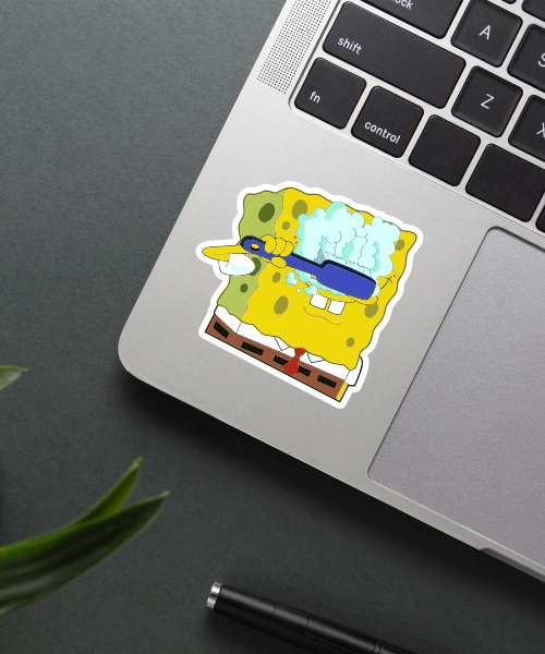 spongebob cleaning eyes sticker on laptop surface showing bright yellow sponge and bubbles
