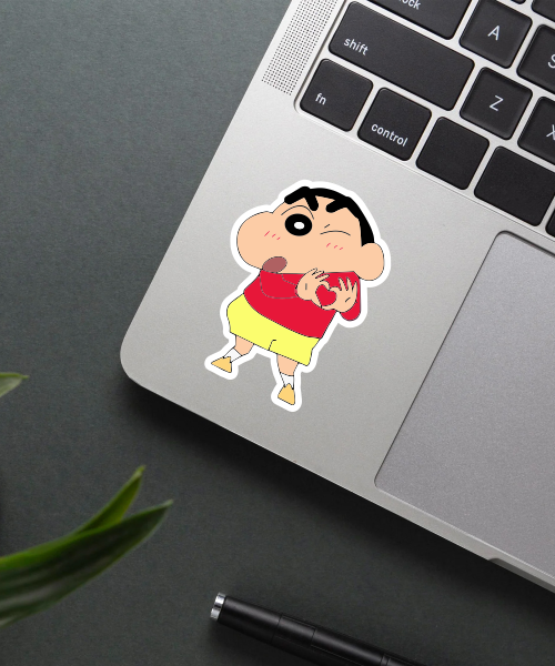 shinchan cartoon sticker on laptop surface showing hand heart pose and bright colors