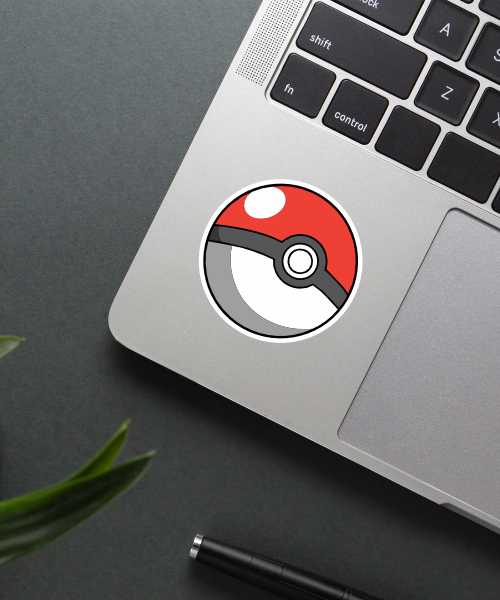 pokeball cartoon sticker on laptop surface showing classic red white colors and black band