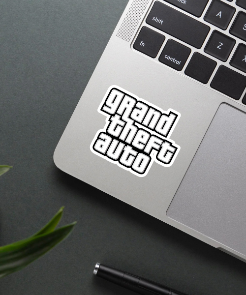 Grand Theft Auto logo sticker on a laptop surface.