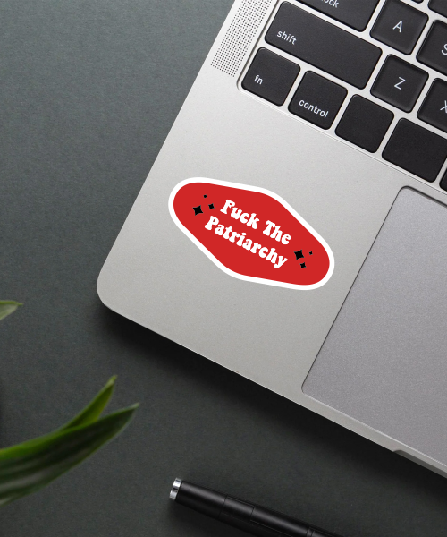patriarchy sticker on laptop surface showing bold red and white text with sparkle accents