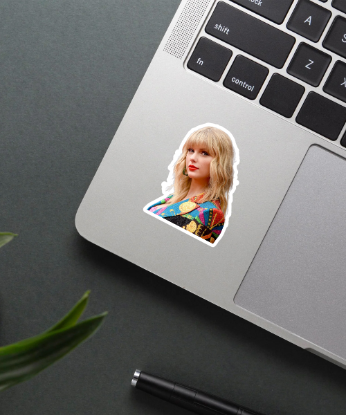taylor swift sticker with colorful jacket on laptop surface