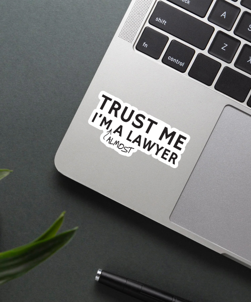 almost a lawyer sticker on laptop surface showing bold black text and handwritten almost