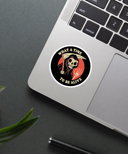 what a time to be alive sticker on laptop surface showing grim reaper design in black red colors