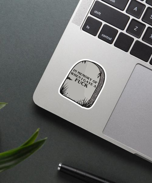 tomestone sticker on laptop showing dark grey tombstone with sarcastic quote