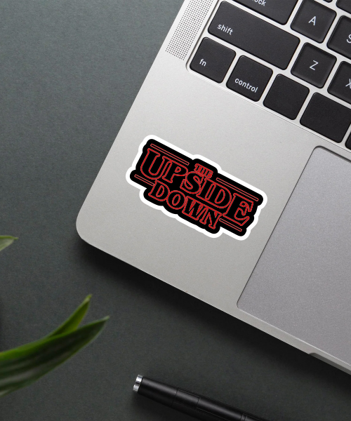 the upside down sticker on laptop surface showing red text on black background