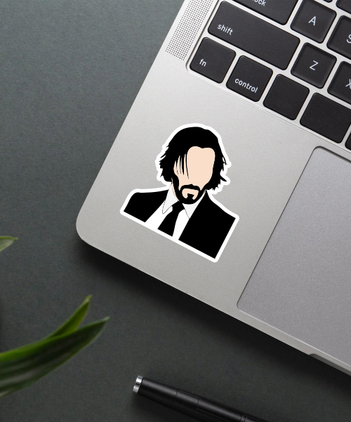 john wick sticker on laptop surface showing minimalist black and white portrait