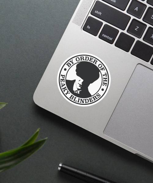 by the order of peaky blinders sticker applied on laptop surface showing black and white round design