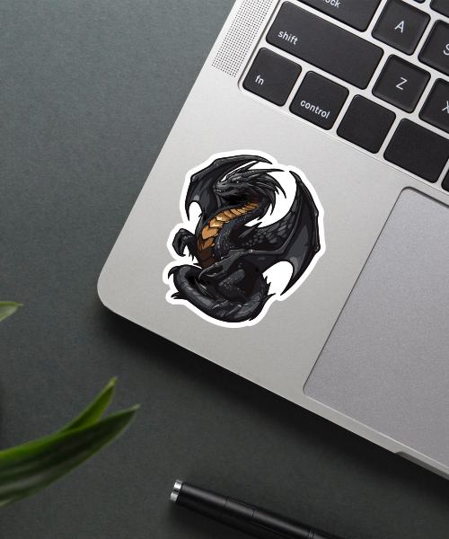 got black dragon sticker on laptop surface showing detailed fantasy dragon design