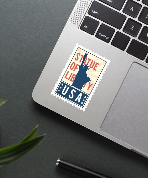 Mockup showing Statue Of Liberty USA travel sticker on laptop with blue red white design.