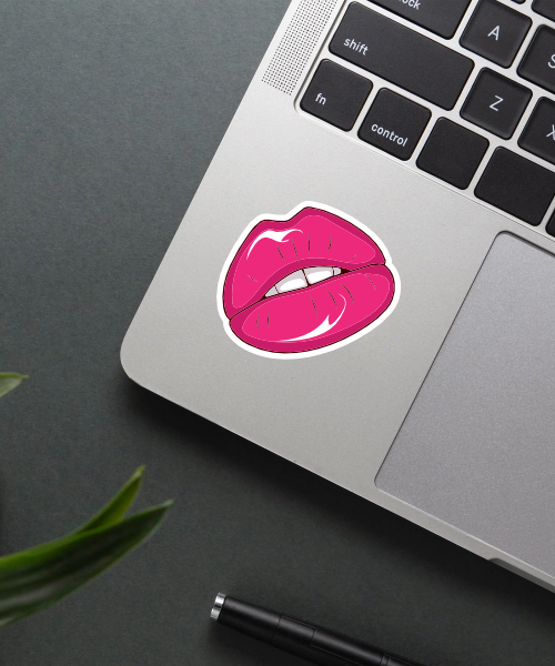 pink lips sticker on laptop surface showing glossy shine and bright color